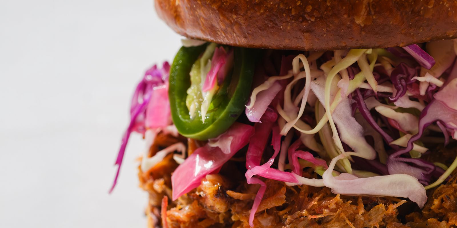A Heritage Eats pulled pork sandwich with pickled slaw and jalapeno